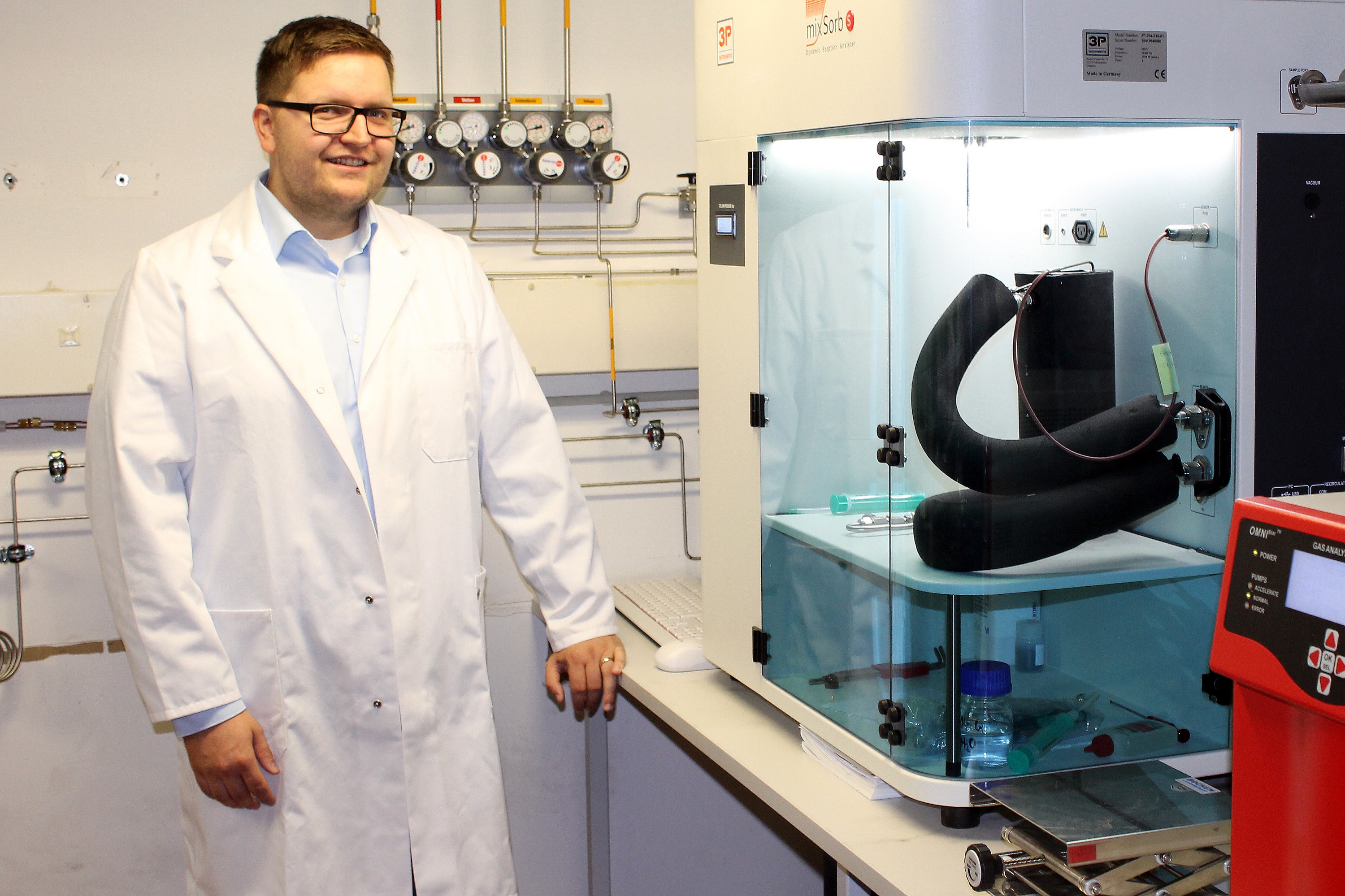 Martin Rieß M.Sc. in front of the measuring system for dynamic gas adsorption in one of Bayreuth’s laboratories for Inorganic Chemistry. Photo: Christian Wißler.